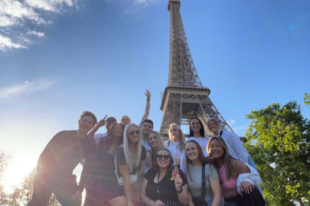 a group of students standing in front of the Eiffel Tower in Paris