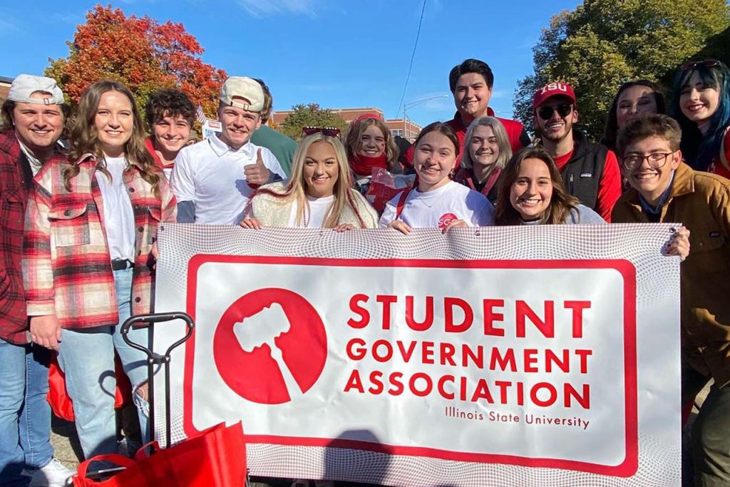 people smiling and holding Student Government Association banner