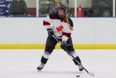 An ISU women's hockey player shoots the puck
