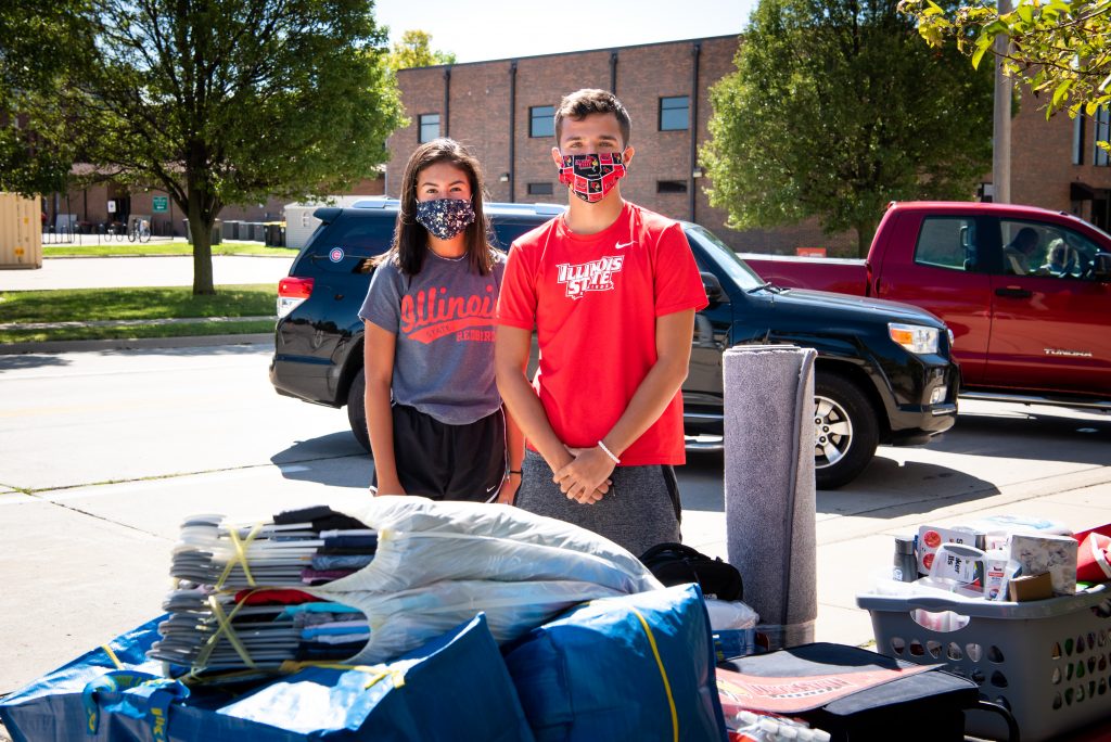Illinois State students pose next to their belongings at move-in.